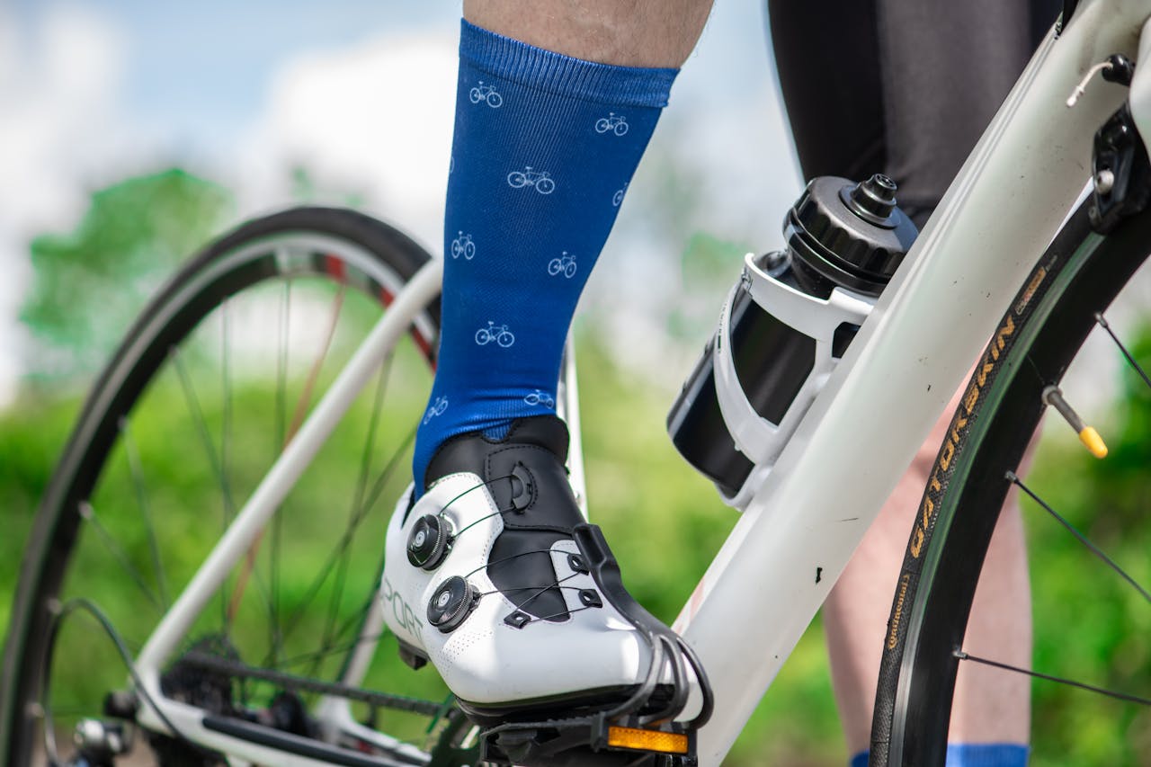 Person Wearing Blue Socks and White Biking Shoes